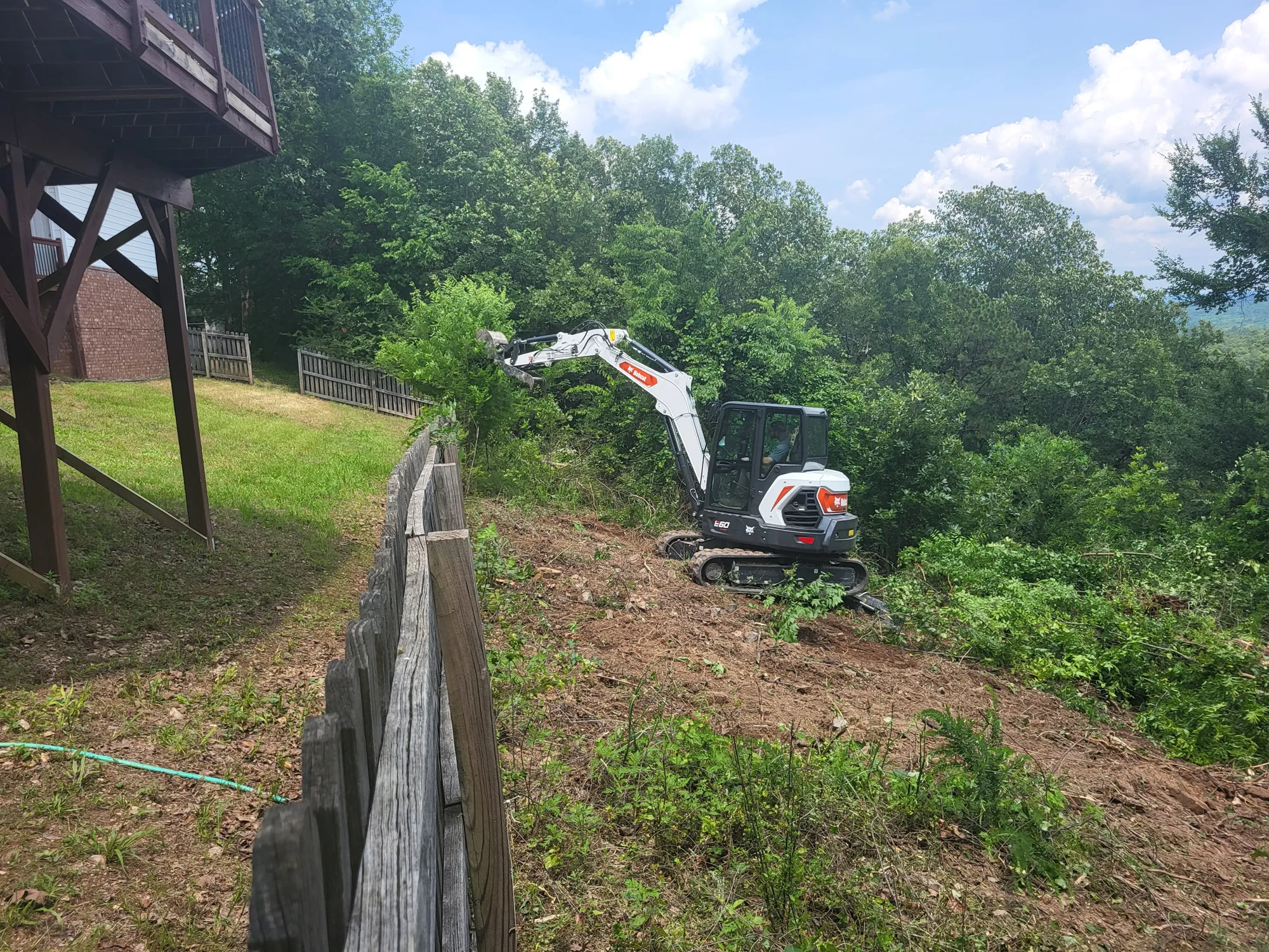 Land-clearing project beside a retaining wall