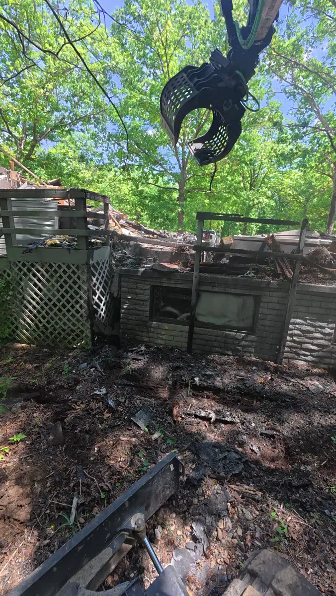 Excavator grapple over demolition debris