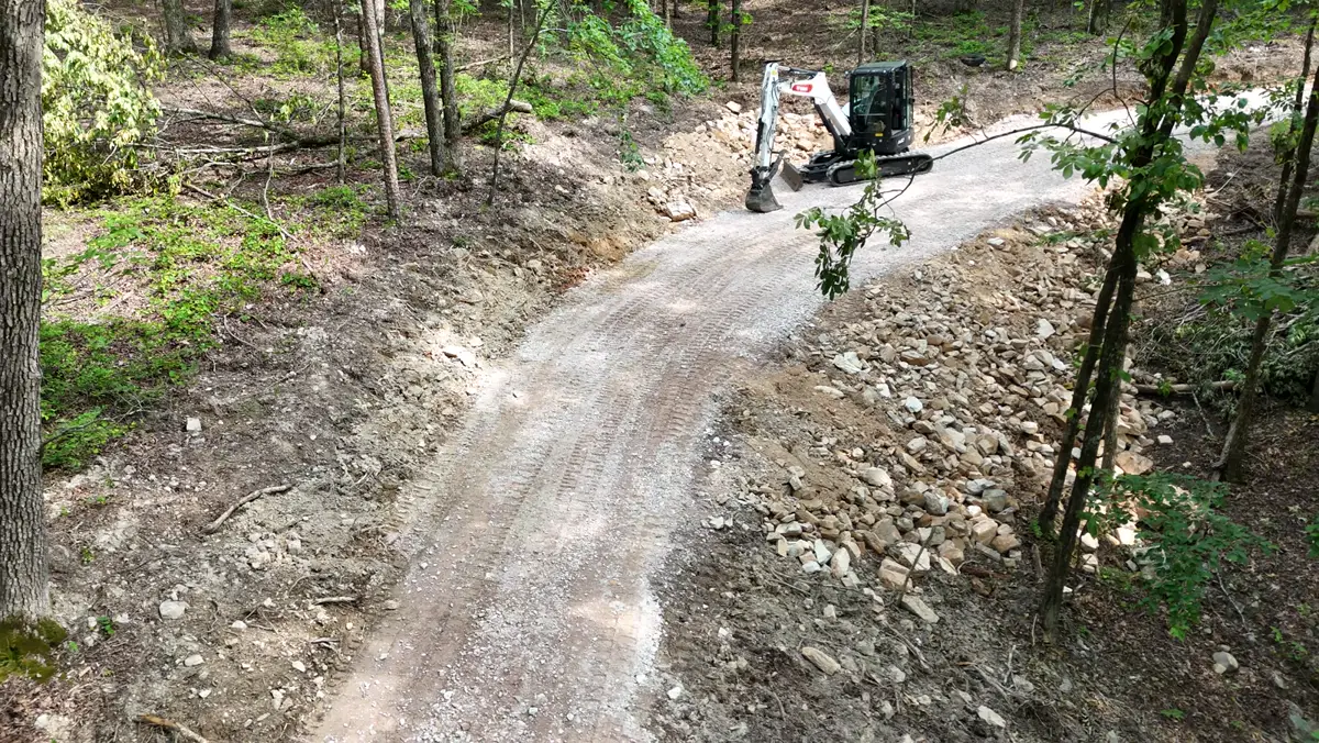 Crushed-stone drive on a slope with a rock edge